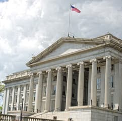 The Federal Reserve building facade under a dramatic sky.