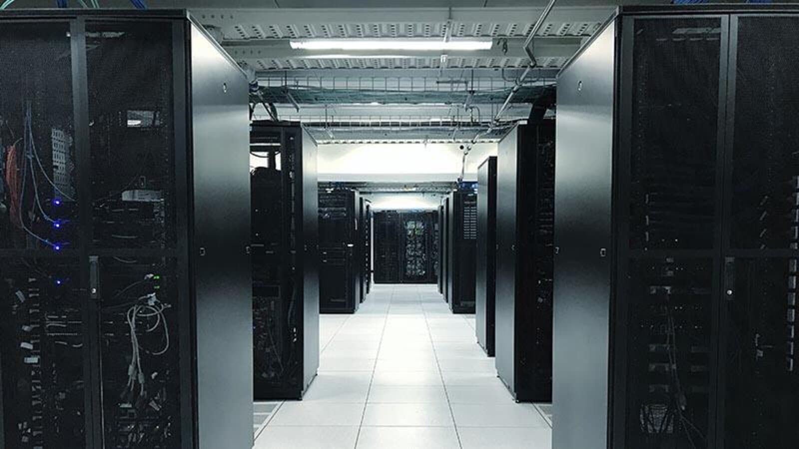 A data center server aisle with rows of illuminated server racks